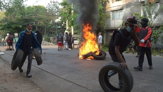 Anti-coup demonstrators gather tires to burn as the prepare to confront police during a protest in Tarmwe township, Yangon, Myanmar. (AP file photo)
