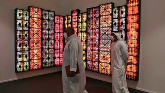 People visit Saudi artist Rashed Al Shashai's work titled Brand 14, Light Boxes, Plastic Cases, at the 14th edition of Art Dubai at Dubai International Financial Centre, DIFC, which features 50 galleries from 31 countries with a focus on modern and contemporary art, in Dubai, United Arab Emirates, Tuesday, March 30, 2021. (AP)