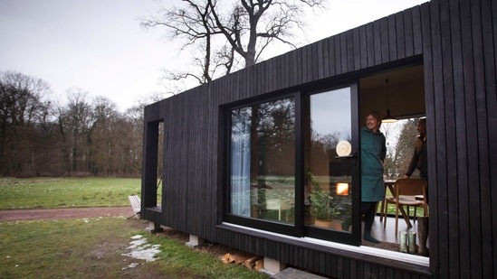 Kim Devos, dari Erpe, Belgia melihat ke luar pintu geser dari Slow Cabin di Elewijt, Belgia, Senin, 15 Februari 2021. (AP)