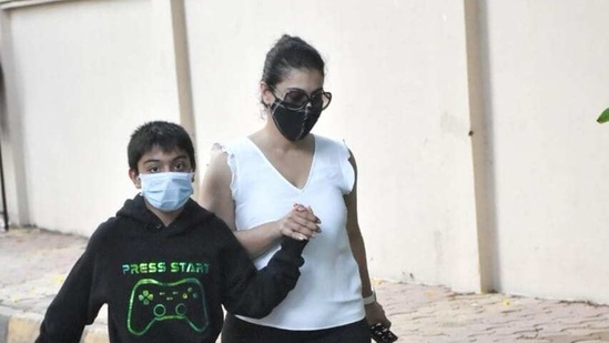 Kajol seen with her son Yug. She held his hand as they walked by some photographers.