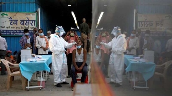 A healthcare worker collects a swab sample from a man, at a temporary shelter for the homeless, in New Delhi, on March 31. India recorded 72,330 new infections of the coronavirus disease (Covid-19) between March 31 and April 1 morning, the highest single-day rise recorded so far this year.(Adnan Abidi / REUTERS)
