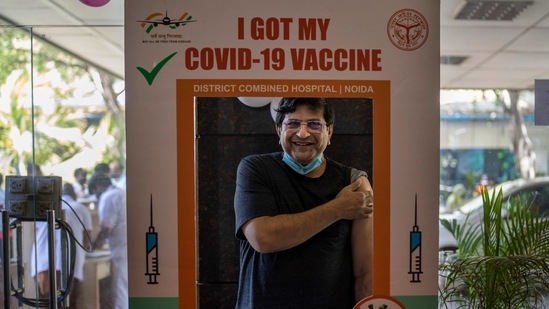 A man poses for a photograph behind a cutout after receiving a Covid- 19 vaccine at a government hospital in Noida, on April 1.(Altaf Qadri / AP)