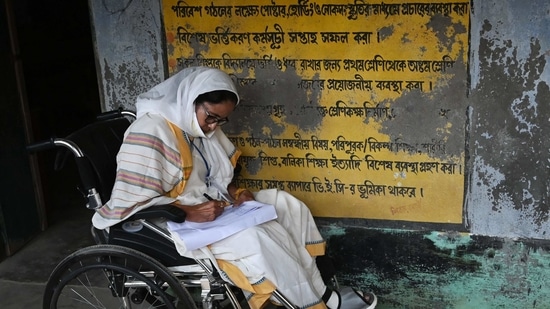 West Bengal's Chief Minister Mamata Banerjee takes notes while sitting in a wheelchair at a polling station during Phase 2 of West Bengal's legislative election in Nandigram on April 1, 2021. (AFP Photo )