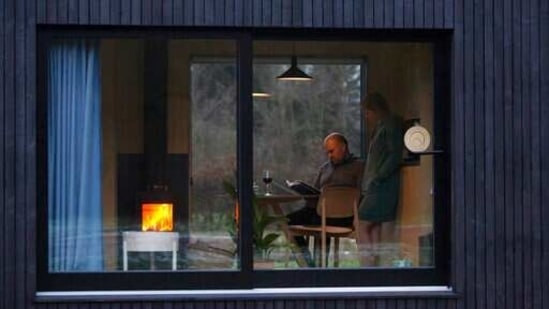 Guy De Deyn dan rekannya Kim Devos menikmati api unggun saat mereka membaca buku bersama di Slow Cabin di Elewijt, Belgia, Senin, 15 Februari 2021. Dengan pembatasan perjalanan diberlakukan di Belgia karena COVID-19, eco- kabin yang ramah mendorong pengunjung untuk bersantai dan terhubung kembali dengan alam dengan membenamkan diri lebih dekat ke rumah dan membuat penemuan baru. (AP)