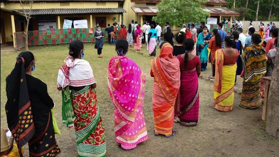 Voters queue up to cast their vote during the second phase of the Assam assembly elections at a polling station in Dhekiabari, Morigaon district on Thursday. (PTI PHOTO.)