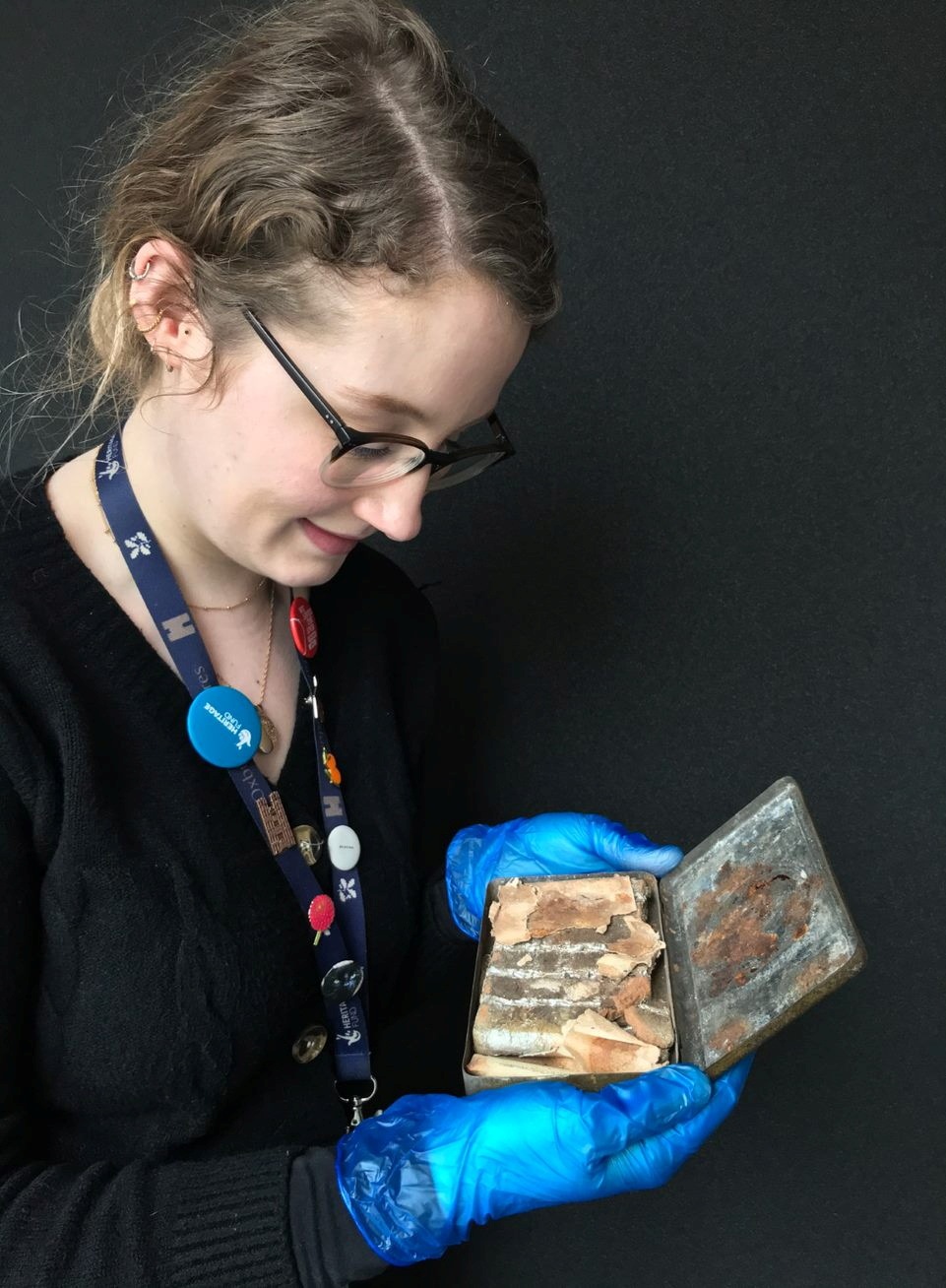 Katherine Bridges, petugas rumah dan koleksi senior di National Trust, memegang sekotak coklat berusia 121 tahun (via REUTERS)