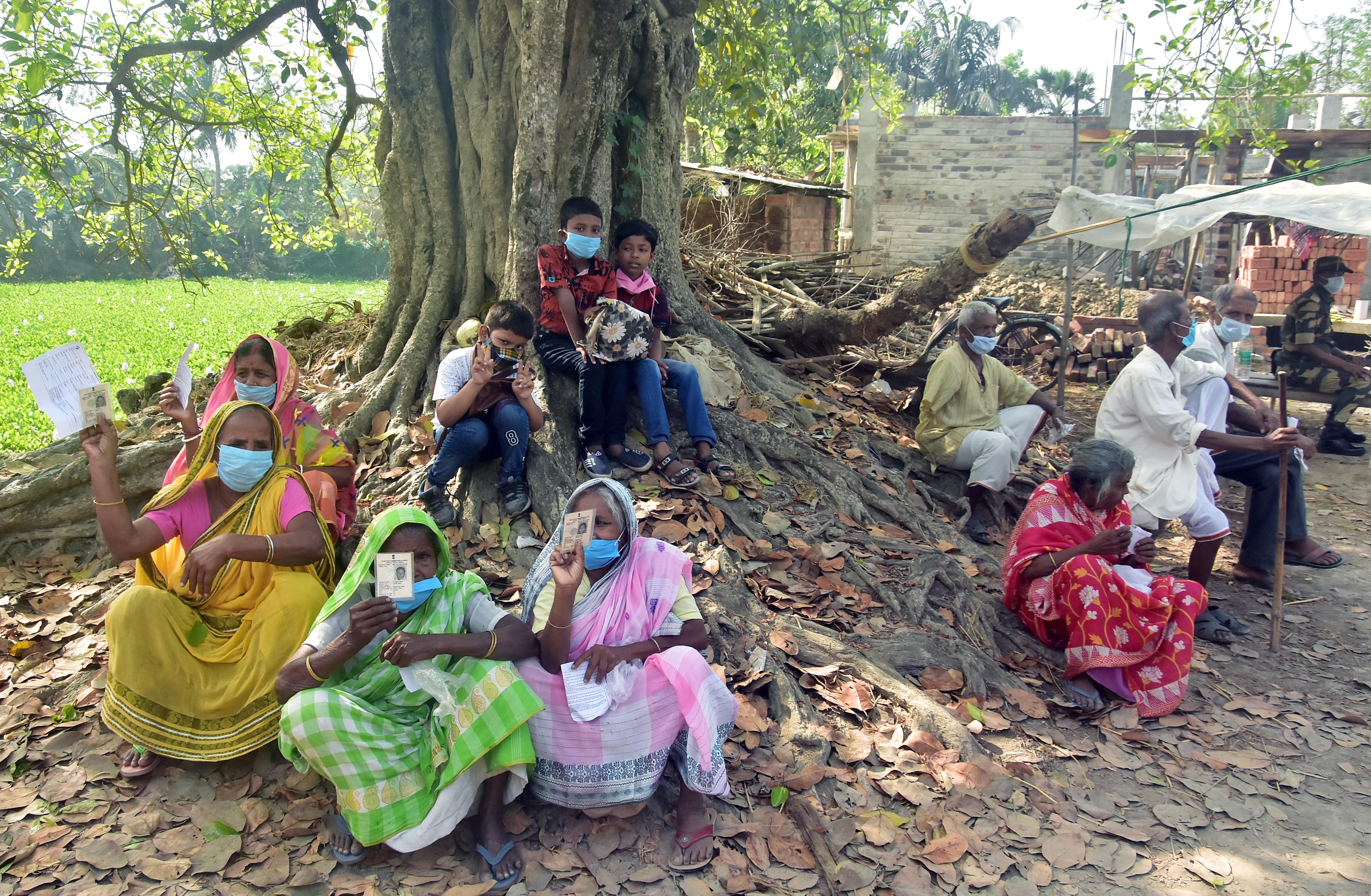 Voters show their Voter-IDs as they wait to cast vote during the second phase of the West Bengal Assembly election. at Nandigram in East Midnapore on Thursday. (ANI Photo) Voters show their Voter-IDs as they wait to cast vote during the second phase of the West Bengal Assembly election. at Nandigram in East Midnapore on Thursday. (ANI Photo)