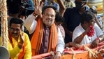 Union Home Minister Amit Shah shows victory sign during a roadshow at Baruipur constituency for his party candidate ahead of state legislative assembly election, in South 24 Parganas district on Friday. (ANI Photo)
