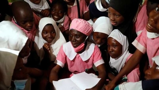 Shade Ajayi, 50, chats with some of her classmates after class, at Ilorin Grammar school, in Ilorin, Kwara state, Nigeria on March 24. Ajayi had never set foot in a classroom until middle age. Now 50, the businesswoman is happily learning to read and write alongside students nearly four decades younger than her.(Temilade Adelaja / REUTERS)