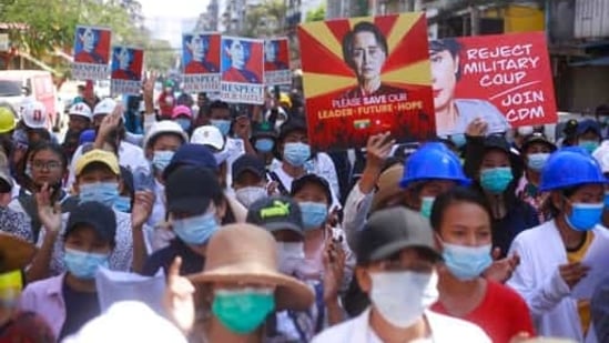 Anti-coup protesters hold up images of deposed leader Aung San Suu Kyi as they gather in Yangon, Myanmar. (AP) Anti-coup protesters hold up images of deposed leader Aung San Suu Kyi as they gather in Yangon, Myanmar. (AP)