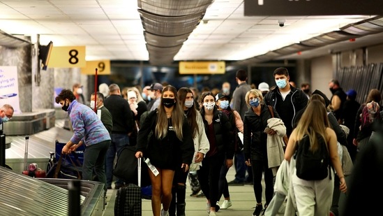 Travellers wearing protective face masks to prevent the spread of Covid-19 reclaim their luggage at the airport in Denver, Colorado. (REUTERS / File)