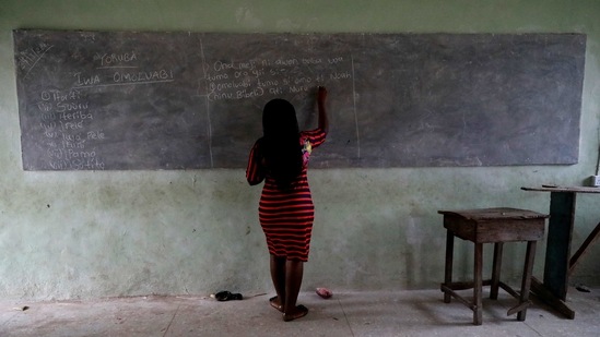 A teacher writes on a chalkboard during a class at Ilorin Grammar School in Ilorin on March 24. Ajayi's teacher, Nasrat Busari, told Reuters that the mature student (Shade Ajayi) appeared completely undeterred by the age gap.(Temilade Adelaja / REUTERS)