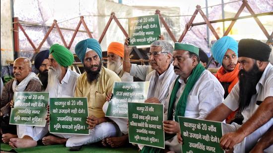 Farmers hold placards during their ongoing protest against the three farm laws at Ghazipur border, in New Delhi on April 1. (ANI)