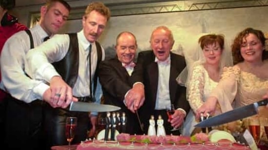 Peter Wittebrood-Lemke, from left, Frank Wittebrood, Ton Jansen, Louis Rogmans, Helene Faasen and Anne-Marie Thus cut the wedding cake after exchanging vows at Amsterdam's City Hall early Sunday, April 1, 2001. The pairs were among four couples to get married under a new law which took effect April 1, 2001, the world's first such law allowing same-sex marriages with equal rights. (AP)