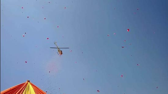 Uttarakhand government helicopter showering flower petals at the religious flag hoisting at Bairagi camp. (HT photo) Uttarakhand government helicopter showering flower petals at the religious flag hoisting at Bairagi camp. (HT photo)