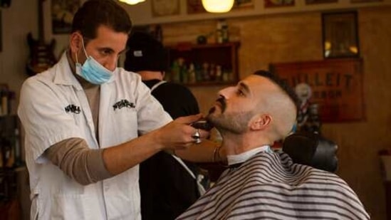 FILE - In this Feb. 23, 2021, file photo, a customer at Nashville Barber Shop gets a shave after coronavirus restrictions were eased in Jerusalem. While Israel provides a glimpse of what may be possible with high immunization rates, it also offers insight into the problems that lie ahead: Workplaces and schools are now grappling with what to do with those who refuse to get vaccinated. (AP)