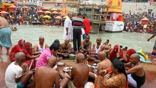 Hindu devotees perform a religious ritual for the departed souls of their relatives on the banks of River Ganges. The Kumbh fest, which is usually held over nearly four months, will be wrapped up this year in just one month due to the Covid-19 pandemic. (AFP) Hindu devotees perform a religious ritual for the departed souls of their relatives on the banks of River Ganges. The Kumbh fest, which is usually held over nearly four months, will be wrapped up this year in just one month due to the Covid-19 pandemic. (AFP)