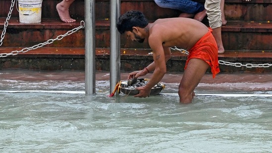 A man looks for coins thrown in the Ganges by devotees after performing religious rituals. (AFP) A man looks for coins thrown in the Ganges by devotees after performing religious rituals. (AFP)