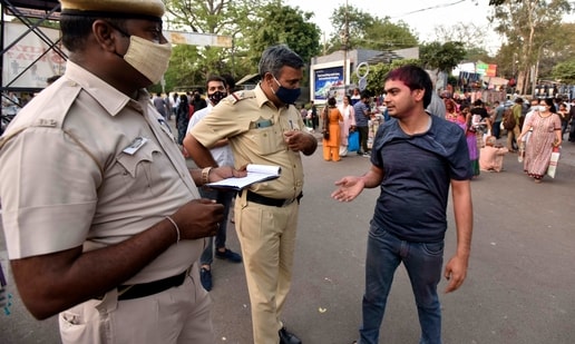 Delhi Police personnel issuing fine to an individual for not wearing a face mask while out in public at Sarojini Nagar Market, in New Delhi. (Sanjeev Verma/ Hindustan Times)