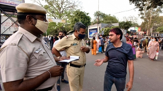 Delhi Police personnel issuing fine to an individual for not wearing a face mask while out in public at Sarojini Nagar Market, in New Delhi. (Sanjeev Verma/ Hindustan Times)
