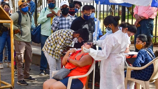 A medic conducts Covid-19 testing of a tourist at Gateway of India as others wait for their turn in Mumbai on Friday. (PTI Photo ) A medic conducts Covid-19 testing of a tourist at Gateway of India as others wait for their turn in Mumbai on Friday. (PTI Photo )