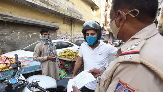 Delhi Police personnel issuing a fine to a motorist for not wearing a face mask and violating Covid-19 norms in Pandav Nagar, New Delhi. (Raj K Raj/HT PHOTO) Delhi Police personnel issuing a fine to a motorist for not wearing a face mask and violating Covid-19 norms in Pandav Nagar, New Delhi. (Raj K Raj/HT PHOTO)