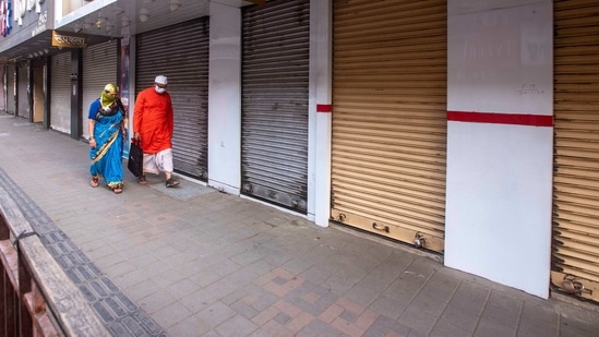 A man and woman walk past shut shops at Laxmi road in Pune. (Pratham Gokhale/HT Photo) A man and woman walk past shut shops at Laxmi road in Pune. (Pratham Gokhale/HT Photo)
