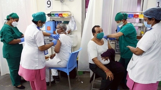 A medic injects a COVID-19 vaccine to people, at Nair Hospital in Dadar on Sunday. (ANI Photo)
