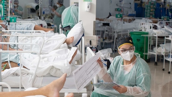 Healthcare workers treat patients inside a Covid-19 ICU at a field hospital in the Heliopolis favela of Sao Paulo, Brazil.(Bloomberg) Healthcare workers treat patients inside a Covid-19 ICU at a field hospital in the Heliopolis favela of Sao Paulo, Brazil.(Bloomberg)