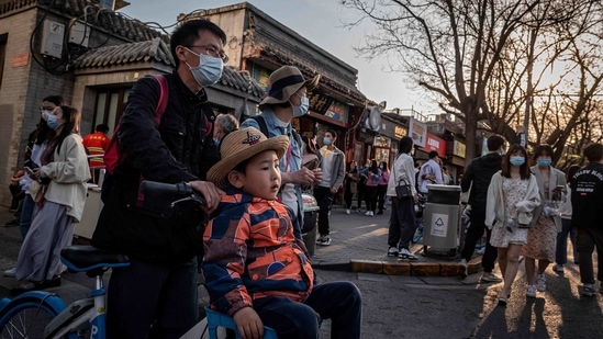 A young boy (C) is pushed along on a bicycle on a street in a traditional neighbourhood in Beijing.(AFP) A young boy (C) is pushed along on a bicycle on a street in a traditional neighbourhood in Beijing.(AFP)