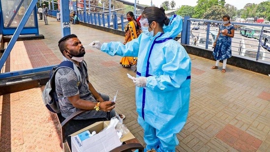 A health worker collecting Covid-19 test sample at Kempegowda bus stand in Bengaluru. (PTI) A health worker collecting Covid-19 test sample at Kempegowda bus stand in Bengaluru. (PTI)