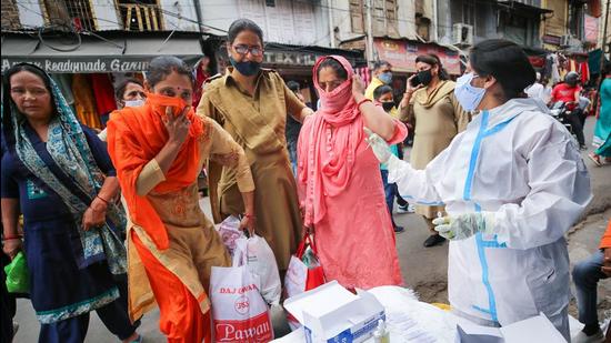 Three women being tested after they were caught without face masks in Jammu on Sunday. (PTI) Three women being tested after they were caught without face masks in Jammu on Sunday. (PTI)