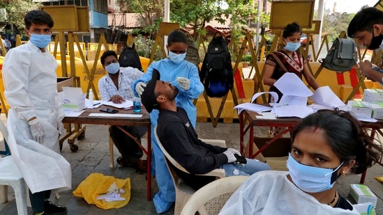 A healthcare worker collects a swab sample from a man during a rapid antigen testing campaign, near Gateway of India, in Mumbai, on April 5. India added 103,796 cases of Covid-19 on April 4, breaching the peak of 99,181 seen in a single day during the first wave of the pandemic in September last year.(Niharika Kulkarni / REUTERS)