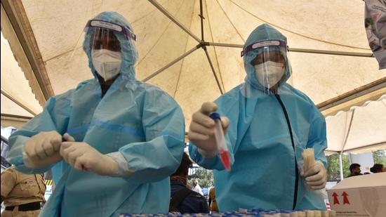 Health workers in PPE coveralls working with swab samples for Covid-19 testing. (Sanchit Khanna/HT Photo) Health workers in PPE coveralls working with swab samples for Covid-19 testing. (Sanchit Khanna/HT Photo)