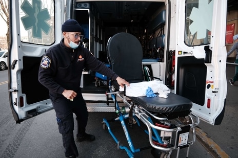 An EMT worker cleans a gurney after transporting a suspected Covid patient outside of a Brooklyn hospital in New York City. (AFP) An EMT worker cleans a gurney after transporting a suspected Covid patient outside of a Brooklyn hospital in New York City. (AFP)