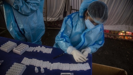 A health worker tests nasal swab samples for Covid-19 infection, in Srinagar, on April 5. The number of cases recorded on April 4 is a sharp increase from the 92,961 reported a day earlier.(Mukhtar Khan / AP)