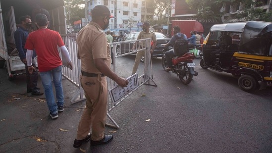 Police personnel prepare barricades at Daruwala Pul in Pune, on April 3. Maharashtra has shut all non-essential shops, restricted restaurants to takeaways, closed places of worship and asked all workplaces that can work remotely to work from home amid the surge in coronavirus cases, HT reported.(Pratham Gokhale / HT Photo)