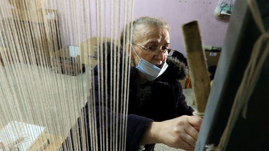 Hate Ora, 64, or 'Aunt Hate' as everyone knows her, weaving a carpet in Kukes town, northeastern Albania, Friday, March 12, 2021. Albania once had 13 former state-run factories that produced carpets, rugs, fez hats, felt folk costumes and other handicrafts. Kukes, a town northeast of the capital, Tirana, alone employed more than 1,200 women as weavers. When the country's communist era ended in 1990, the local factory closed. (AP Photo/Hektor Pustina)(AP)