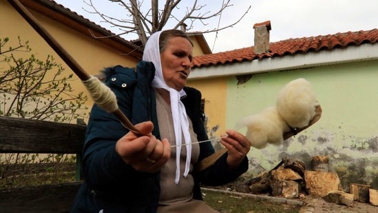 Mereme Pepa, 68, spinning the wool in Nange village, northeastern Albania, Friday, March 12, 2021.(AP)