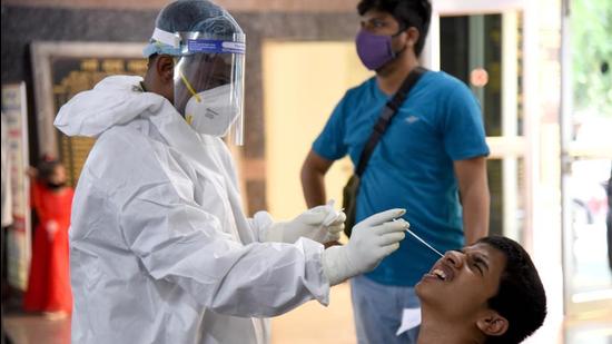 A medic conducts RT-PCR test for Covid-19 at NMMC hospital, Vashi, in Navi Mumbai. (HT file)