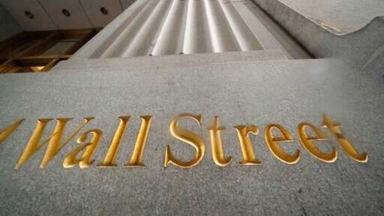 FILE - In this Nov. 5, 2020 file photo, a sign for Wall Street is carved in the side of a building. Stocks are opening higher on Wall Street led by gains in Big Tech companies. The S&amp;P 500 was up 0.4% early Wednesday, March 31, 2021. (AP)