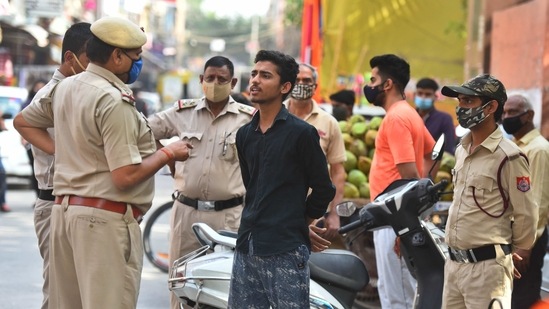New Delhi, India - March 28, 2021: Delhi Police personnel issuing a fine to a motorist for not wearing a face mask and violating Covid-19 norms in Pandav Nagar, New Delhi, India, on Sunday, March 28, 2021. (Photo by Raj K Raj/ Hindustan Times) (Raj K Raj/HT PHOTO) New Delhi, India - March 28, 2021: Delhi Police personnel issuing a fine to a motorist for not wearing a face mask and violating Covid-19 norms in Pandav Nagar, New Delhi, India, on Sunday, March 28, 2021. (Photo by Raj K Raj/ Hindustan Times) (Raj K Raj/HT PHOTO)