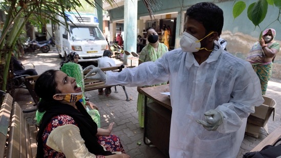 A BMC healthcare worker takes a swab sample during Covid-19 screening, at Kherwadi in Mumbai on Tuesday.(Satish Bate/HT Photo)