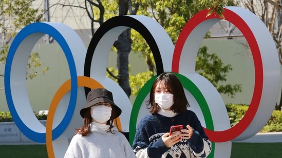 People walk past the Olympic rings in Tokyo.(AP) People walk past the Olympic rings in Tokyo.(AP)
