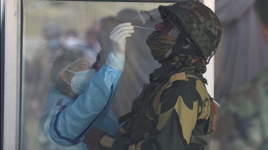 A health worker takes a nasal swab sample of a BSF man at a test centre in Srinagar on Tuesday. (Waseem Andrabi/HT) A health worker takes a nasal swab sample of a BSF man at a test centre in Srinagar on Tuesday. (Waseem Andrabi/HT)