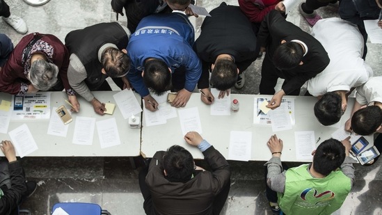 People filing out consent forms at a Covid-19 vaccination center in Shanghai on April 3. Ruili had on April 2 launched a five-day drive to vaccinate its entire population, with state media showing people lining up to get the jab. The outbreak is something of an anomaly in a country that has all-but eliminated local transmission of the virus, AP reported.(Qilai Shen/Bloomberg)