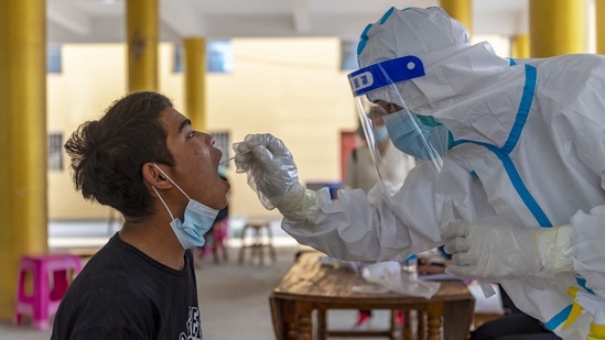 A resident receives nucleic acid testing for Covid-19 at Mengmao Village in Ruili City on March 31. China’s National Health Commission reported an additional 20 cases on April 5, five of them in which the persons showed no symptoms. The cases were detected during city-wide nucleic acid testing, bringing the city’s total to 51 confirmed cases and 56 asymptomatic cases, which China has placed in a separate category.(Chen Xinbo/Xinhua via AP)