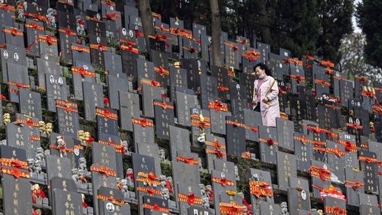 A woman visting a tomb during Qingming Festival on April 3 in Wuhan. China has reported 90,305 total cases and 4,636 deaths, with 238 patients being treated in hospitals for Covid-19, which was first detected in the central Chinese city of Wuhan in late 2019.(Getty Images)