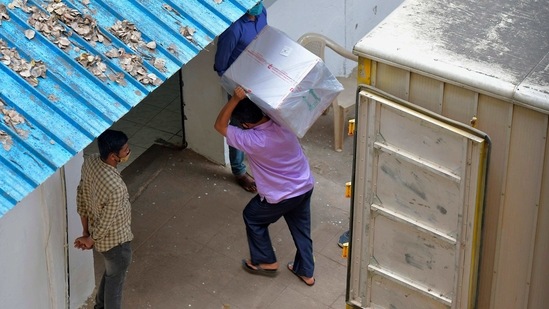 Workers transfer carton boxes of a Covishield vaccine developed by Pune based Serum Institute of India (SII) that arrived in a truck into the Karnataka Health Department cold storage facility in Bangalore in this file picture. (AFP)