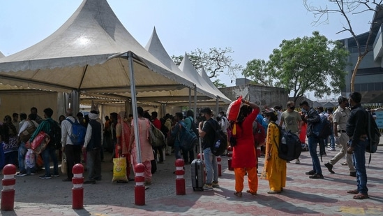 Passengers stand in a queue to register for a RT-PCR test at a bus stand in New Delhi on Tuesday. (AFP Photo) Passengers stand in a queue to register for a RT-PCR test at a bus stand in New Delhi on Tuesday. (AFP Photo)